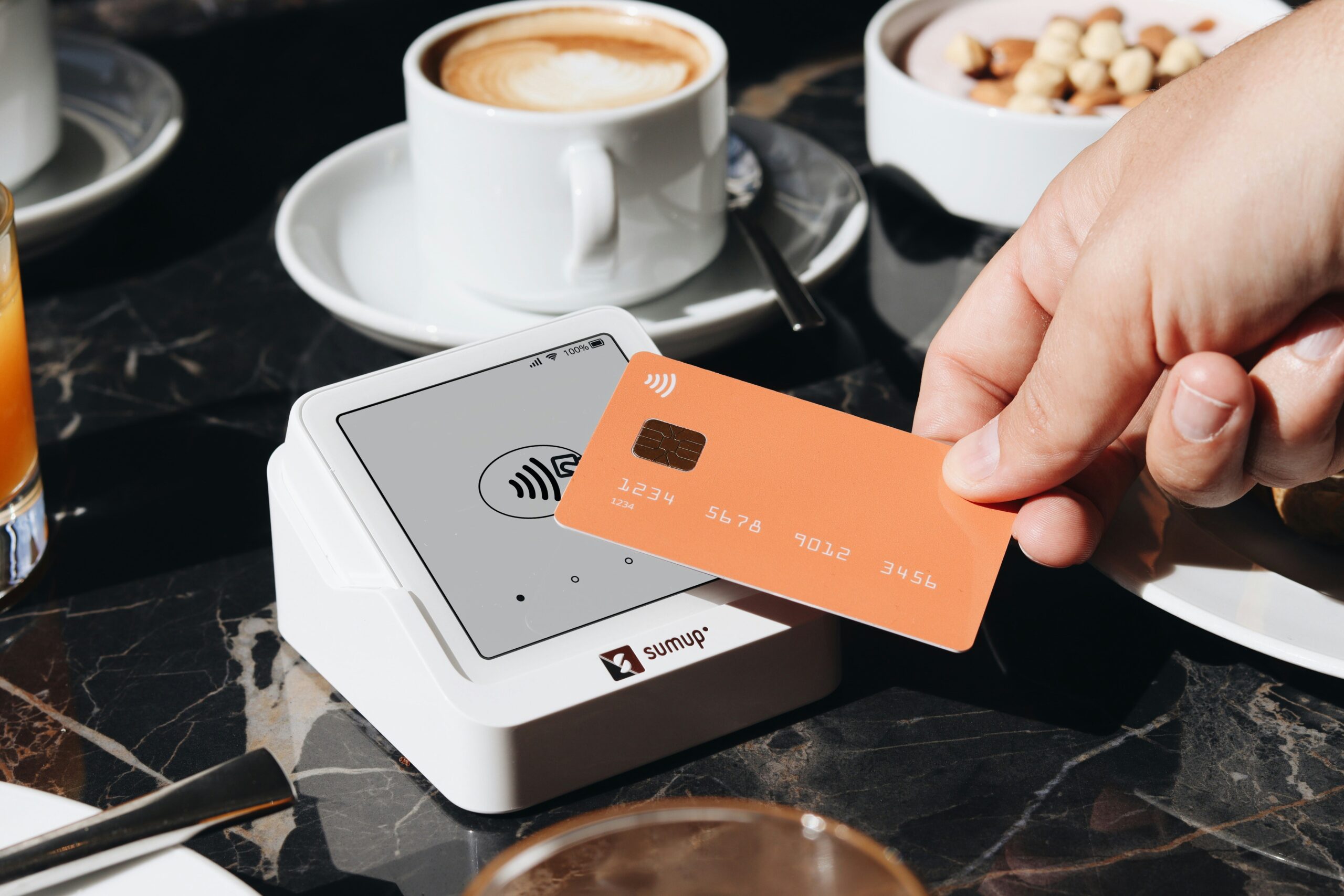 A person holding a credit card over a table