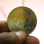 a person holding a bit coin in their hand
