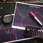 Stock report with charts, calculator, and magnifying glass for financial analysis.