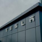 A sleek Tesla building exterior in Ankara, displaying the iconic Tesla logo against a cloudy sky.