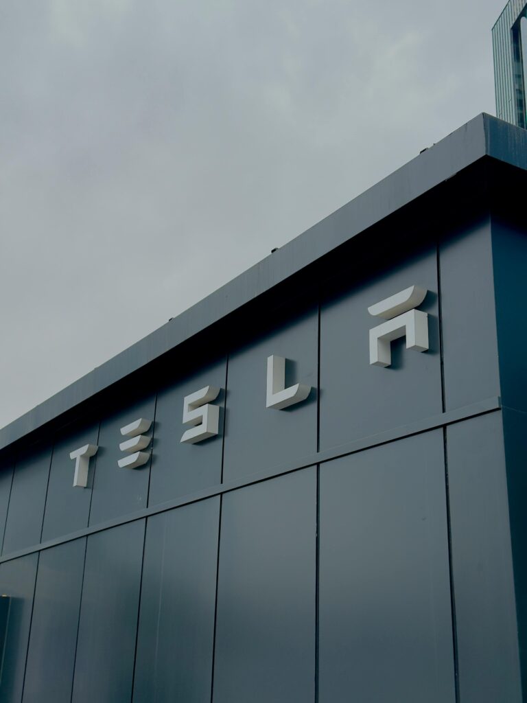 A sleek Tesla building exterior in Ankara, displaying the iconic Tesla logo against a cloudy sky.